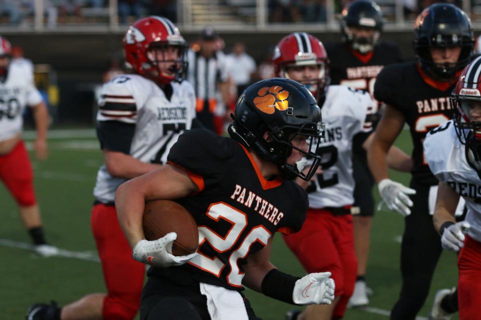 New Lexington's Hunter Rose carries the ball against Coshocton.