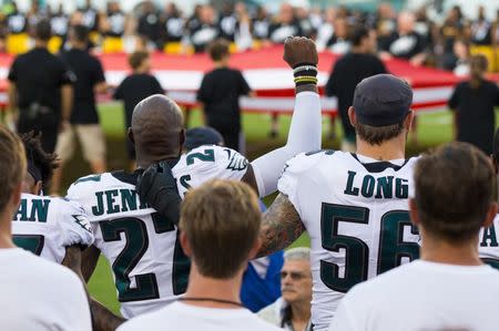 Aug 9, 2018; Philadelphia, PA, USA; Philadelphia Eagles defensive end Chris Long (56) puts his arm around defensive back Malcolm Jenkins (27) as he raises his fist for the national anthem before a game against the Pittsburgh Steelers at Lincoln Financial Field. Mandatory Credit: Bill Streicher-USA TODAY Sports