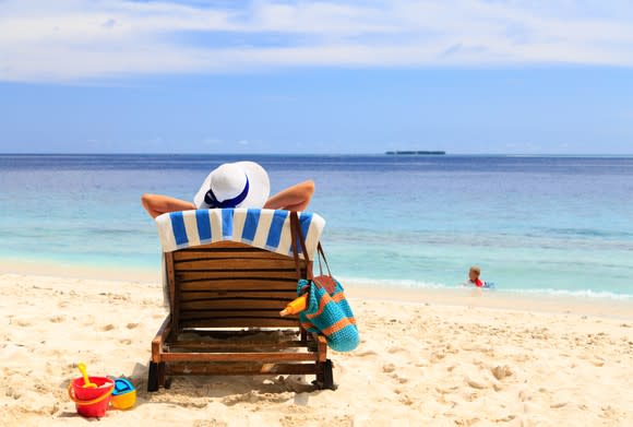 A woman sitting in a beach chair on a beach.