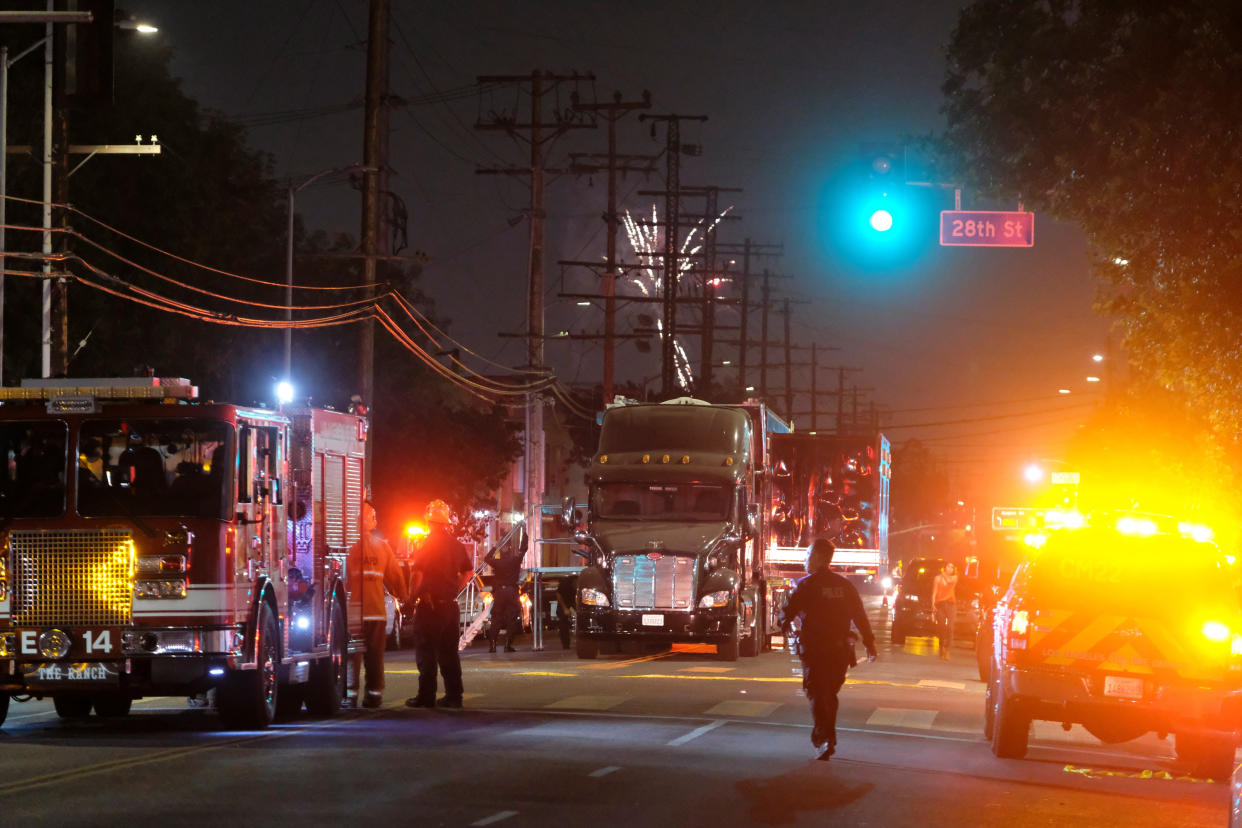 Fireworks continue to fill the skyline as emergency personnel respond to the explosion of an armored Los Angeles Police Department tractor-trailer in South Los Angeles Wednesday evening, June 30, 2021. A cache of illegal fireworks seized at a South Los Angeles home exploded, damaging nearby homes and cars and causing injuries, authorities said. (AP Photo/Ringo H.W. Chiu)