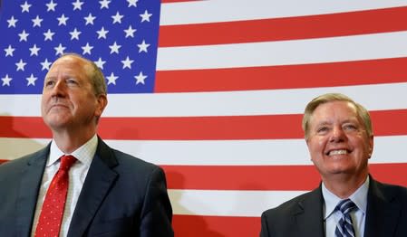 North Carolina’s 9th District Republican candidate Dan Bishop and South Carolina Senator Lindsay Graham listen as U.S. President Donald Trump speaks during a campaign rally in Fayetteville, North Carolina