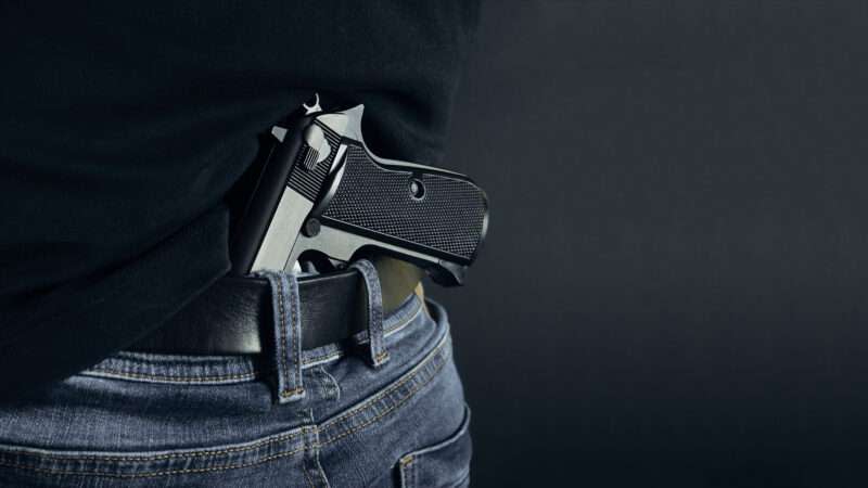 A pistol tucked into the back waistband of somebody's pants.