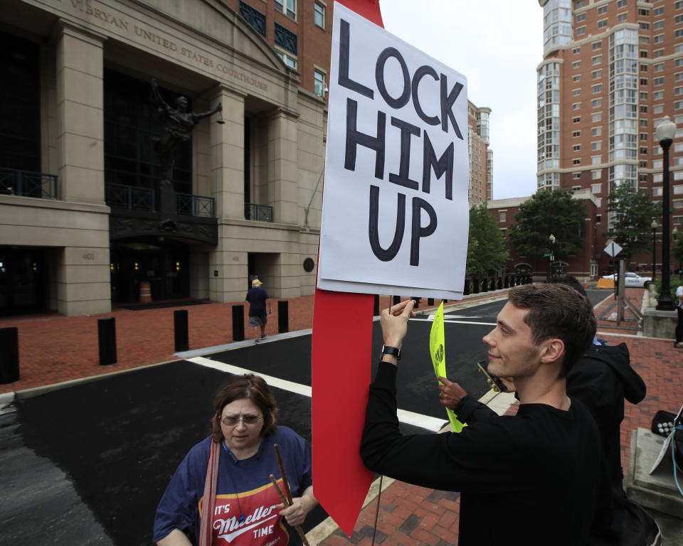 Protesters Gayelynn Taxey, left, and Danny Hastings, stand in front of the Alexandria Federal Court in Alexandria, Va., Tuesday, July 31, 2018, on day one of Paul Manafort's trial. (AP Photo/Manuel Balce Ceneta)