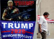 A man walks past banners of U.S. President Donald Trump near the BOK Center in Tulsa