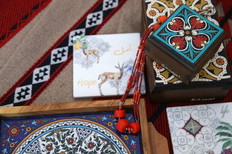 Handmade items from Palestine, including boxes, jewelry, coasters and a coffee tray are situated on a picnic blanket Tuesday, Jan. 16, 2024 in Deema Totah's home in Iowa City, Iowa.