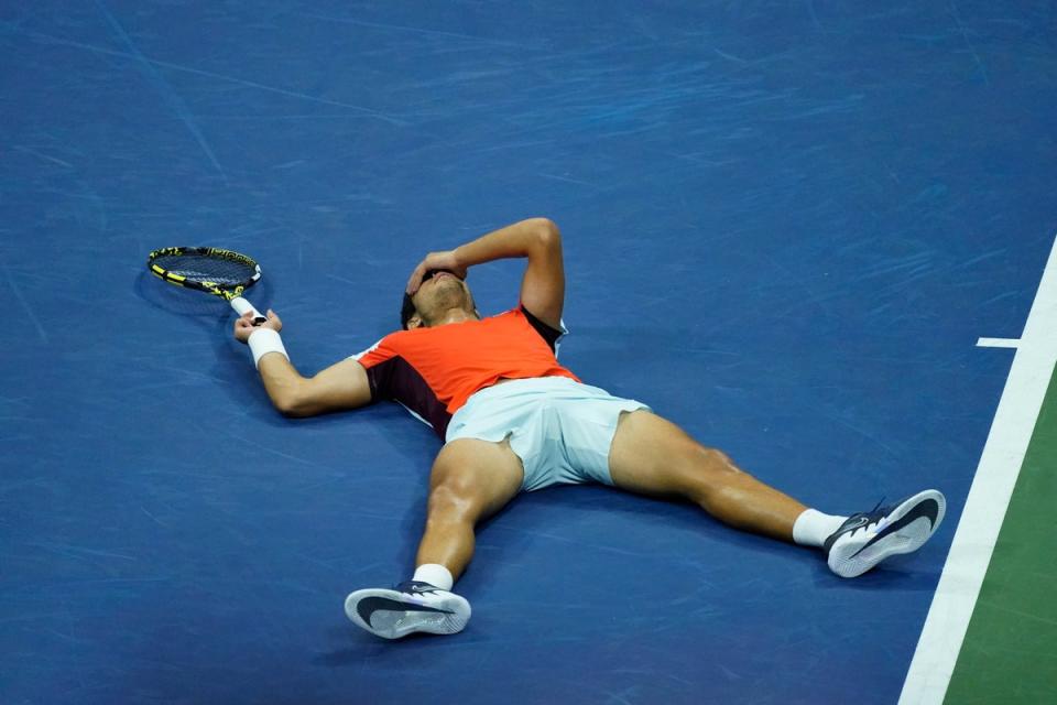 Carlos Alcaraz lies on the court after beating Jannik Sinner (Julia Nikhinson/AP) (AP)
