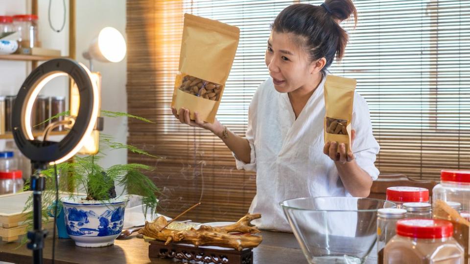 Mujer anunciando productos frente a una cámara.