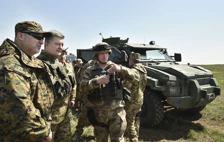 Ukraine's President Petro Poroshenko (2nd L) listens to explanations as he inspects a military drill, with the National Security and Defence Council Oleksandr Turchynov (L) seen nearby, at a training ground near the city of Mykolaiv April 25, 2015. REUTERS/Mykola Lazarenko/Ukrainian Presidential Press Service/Handout via Reuters ATTENTION EDITORS - THIS PICTURE WAS PROVIDED BY A THIRD PARTY. REUTERS IS UNABLE TO INDEPENDENTLY VERIFY THE AUTHENTICITY, CONTENT, LOCATION OR DATE OF THIS IMAGE. FOR EDITORIAL USE ONLY. NOT FOR SALE FOR MARKETING OR ADVERTISING CAMPAIGNS. THIS PICTURE IS DISTRIBUTED EXACTLY AS RECEIVED BY REUTERS, AS A SERVICE TO CLIENTS