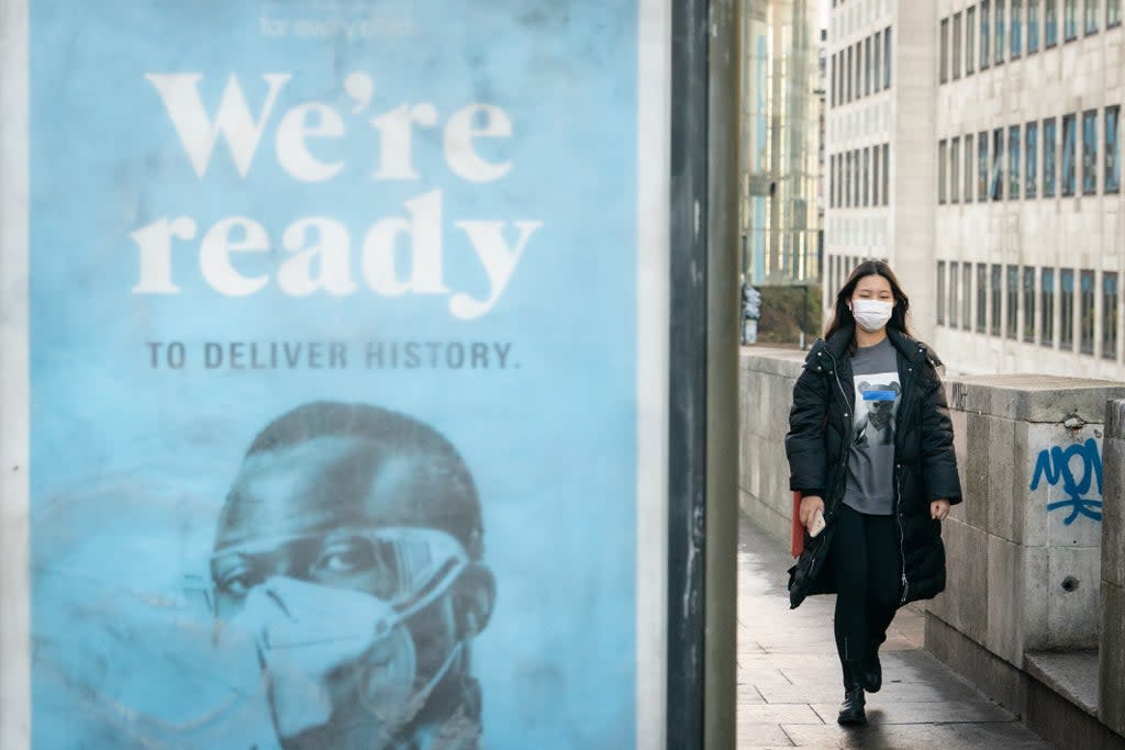 A woman wearing a face mask crosses Waterloo Bridge, London, after Prime Minister Boris Johnson announced that Plan B measures across England will be scrapped (Dominic Lipinski/PA) (PA Wire)