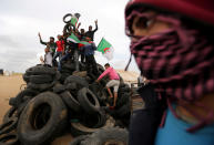 <p>Palestinian activists collect tyres to be burnt along the Israel-Gaza border, in the southern Gaza Strip, April 3, 2018. (Photo: Ibraheem Abu Mustafa/Reuters) </p>
