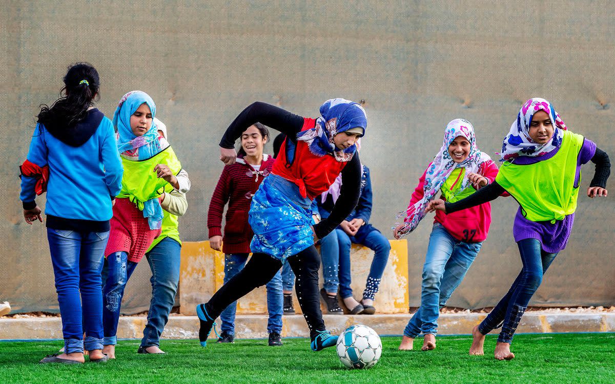 Girls playing football at on the Arsenal-funded pitch at Zaatari refugee camp - Pim Ras/Save the Children