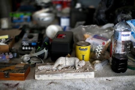 A model of a victim, made by restorers, lies amidst tools in the restoration site at the UNESCO World Heritage site of Pompeii, October 13, 2015. REUTERS/Alessandro Bianchi