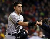 New York Yankees' Jacoby Ellsbury receives a fist-bump after scoring on a single by Derek Jeter during the fifth inning of a baseball game against the Boston Red Sox at Fenway Park in Boston, Tuesday, April 22, 2014. (AP Photo/Elise Amendola)