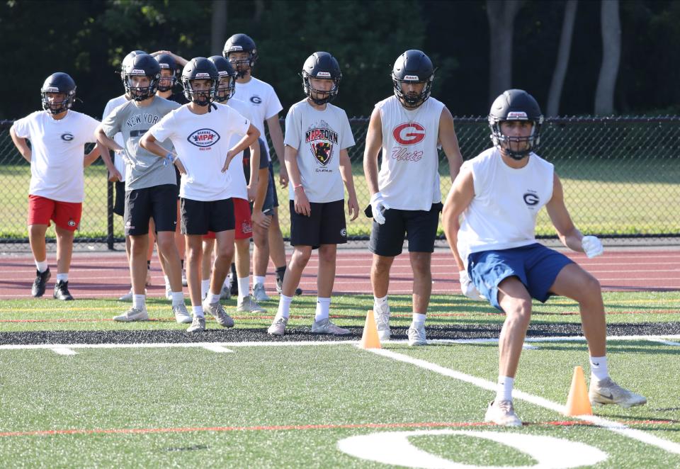 Football players run drills on the first day of Varsity and Junior Varsity football practice at Rye High School, Aug. 20, 2022.