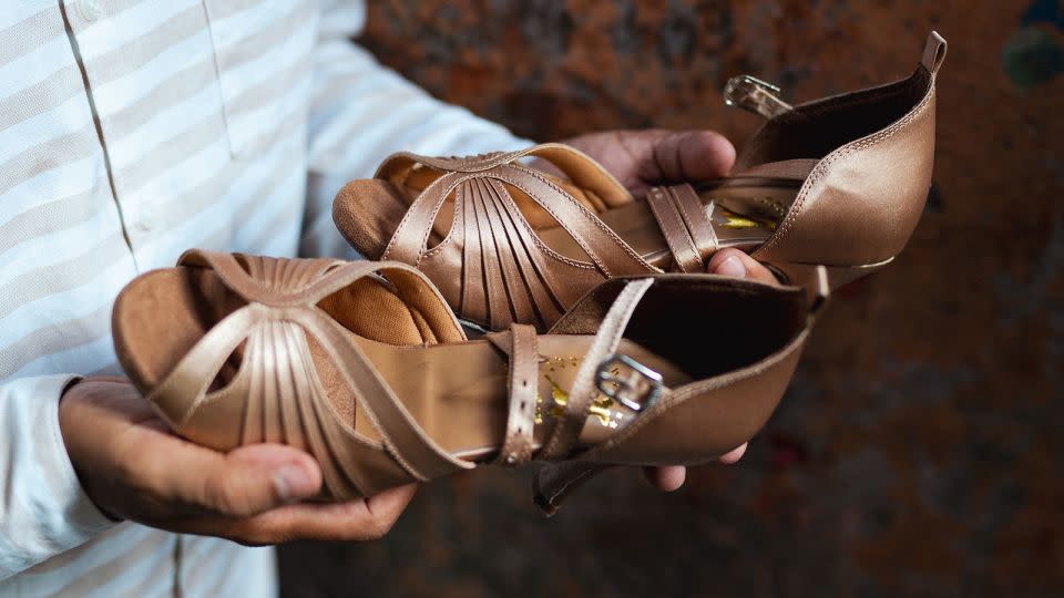 Shah shows the finished shoes produced at his workshop in Mumbai on April 14, 2024. - Noemi Cassanelli/CNN