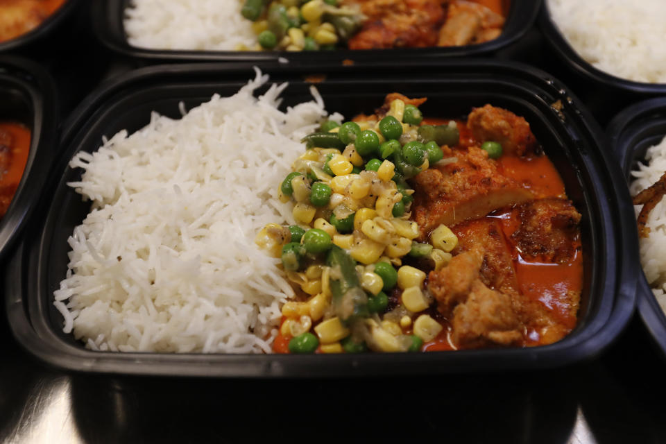 Tandoori Chicken with rice, beans, peas, and sweet corn in a makhani sauce is one of two dishes prepared at the Indian restaurant ROOH, that will be delivered to I Grow Chicago in the Englewood neighborhood of Chicago on Monday, July 13, 2020. ROOH is one of hundreds of eateries around the nation working with the non-profit organization World Central Kitchen to produce meals for the hungry. (AP Photo/Charles Rex Arbogast)