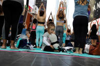 <p>A young girl sucks her thumb as people participate in a yoga class during an annual Solstice event in the Times Square district of New York, U.S., June 21, 2017. (Photo: Lucas Jackson/Reuters) </p>