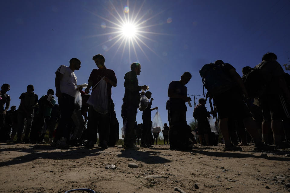 Migrants wait to be processed by the U.S. Customs and Border Patrol after they crossed the Rio Grande and entered the U.S. from Mexico, Thursday, Oct. 19, 2023, in Eagle Pass, Texas. Starting in March, Texas will give police even broader power to arrest migrants while also allowing local judges to order them out of the U.S. under a new law signed by Republican Gov. Greg Abbott. (AP Photo/Eric Gay)