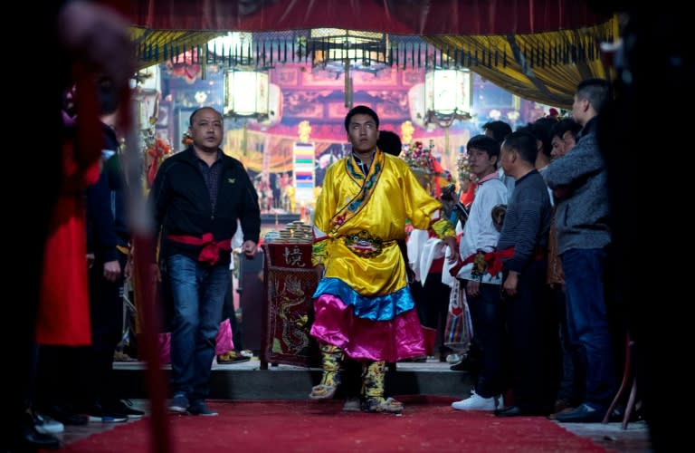 A villager in Fangshan in China's coastal province of Fujian prepares to perform the 'eating flowers' ritual