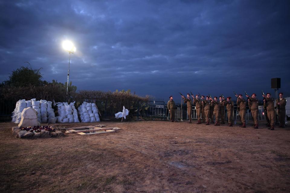 Israeli soldiers from a paratroopers unit rehearse at the grave site for late Israeli Prime Minister Ariel Sharon, who will be buried next to his wife, outside his ranch in Havat Hashikmim, southern Israel, Sunday, Jan. 12, 2014. A state memorial is planned for Monday with the participation of Israeli and world leaders, the prime minister's office said. (AP Photo/Tsafrir Abayov)