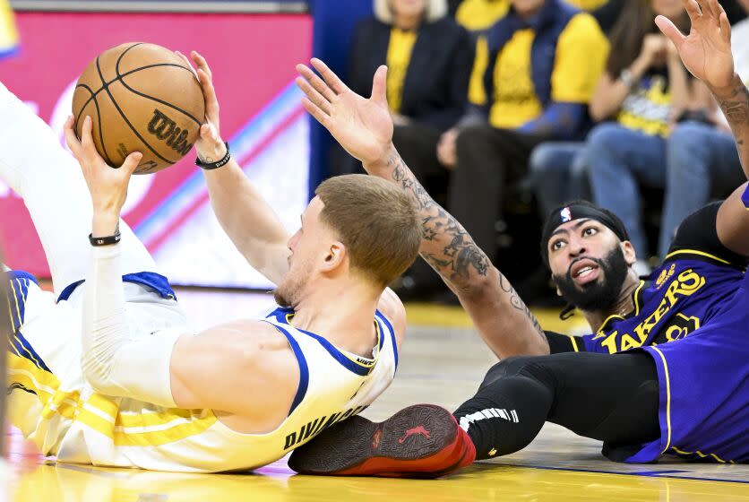 San Francisco, CA - MAY 04: Golden State Warriors guard Donte DiVincenzo, left, grabs onto a loose ball against Los Angeles Lakers forward Anthony Davis during the second half at Chase Center on Thursday May 4, 2023 in San Francisco, CA.(Wally Skalij / Los Angeles Times)