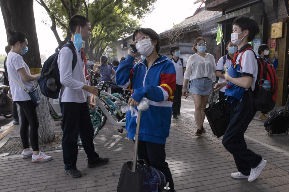 Students wearing masks to curb the spread the new coronavirus leave after the end of a school day in Beijing on Wednesday, June 3, 2020. Students in the Chinese capital have been slowly returning to school as authorities continue to restore normalcy after the shutdown over the coronavirus outbreak. (AP Photo/Ng Han Guan)