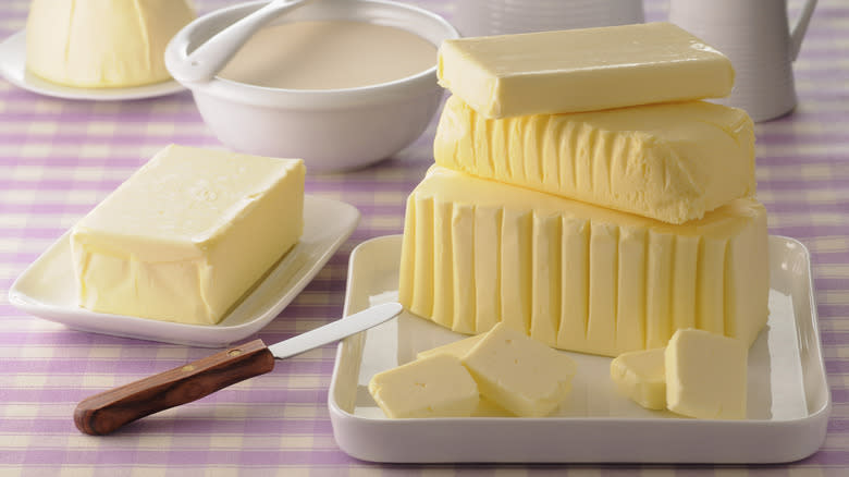 Stack of butter in a dish on a pink plaid tablecloth