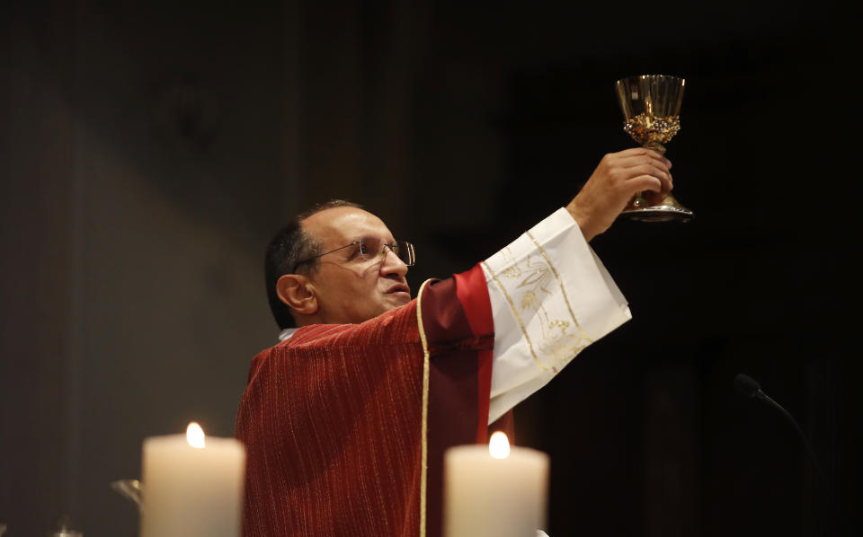 Rev. Mario Carminati celebrates Mass inside the Santissima Redentore church in Seriate, near Bergamo, Italy, Sunday, Sept. 27, 2020. As the world counts more than 1 million COVID victims, the quiet of everyday life and hum of industry has returned to Bergamo, which along with the surrounding Lombardy region was the onetime epicenter of the outbreak in Europe. (AP Photo/Antonio Calanni)