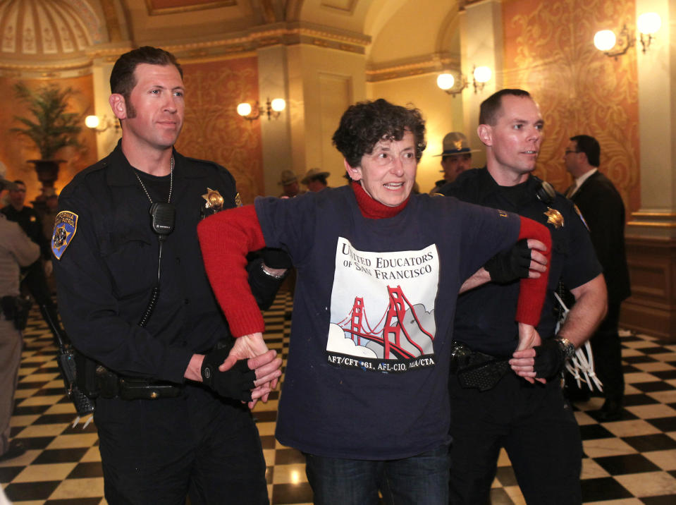 California Highway Patrol Officers remove a protester after she refused to leave the state Capitol in Sacramento, Calif. Monday, March 5, 2012. Dozens of protesters were arrested after repeated warnings to leave the Capitol after it closed. The arrests capped off a day of protests over cuts to higher education.(AP Photo/Rich Pedroncelli)