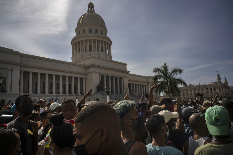 People protest in front of the Capitol in Havana, Cuba, Sunday, July 11, 2021. Hundreds of demonstrators went out to the streets in several cities in Cuba to protest against ongoing food shortages and high prices of foodstuffs, amid the new coronavirus crisis. (AP Photo/Ramon Espinosa)