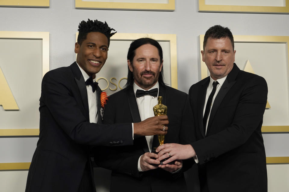 Jon Batiste, from left, Trent Reznor and Atticus Ross, winners of the award for best original score for 