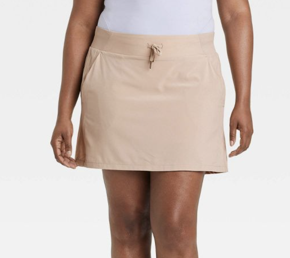 Person wearing beige tennis skirt