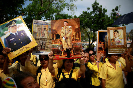 People hold photos of Thailand's newly crowned King Maha Vajiralongkorn before a coronation procession, near the Grand Palace in Bangkok, Thailand May 5, 2019. REUTERS/Navesh Chitrakar