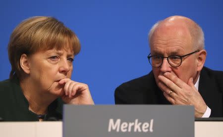 German Chancellor and leader of the conservative Christian Democratic Union party CDU Angela Merkel talks to parliamentary floor leader Volker Kauder (R) at the CDU party convention in Essen, Germany, December 7, 2016. REUTERS/Kai Pfaffenbach