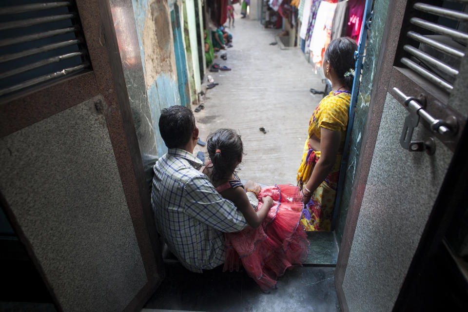 MAHARASHTRA, INDIA - NOVEMBER 12:  5 year old Nirmala (name changed), who was raped by her mother's boss, poses for a photo with her mother and father on November 12, 2015 in Maharashtra, India. One day Nirmala's mother gave her money to go to the corner store and buy food. While Nirmala was walking the man came up to her and offered to buy her candy. He took her to a wooded area behind an apartment building complex, raped her, and inserted a pen inside her. He left her naked and bleeding heavily. She required two surgeries and stayed in the hospital for three months. They caught the man two weeks later. Since he's been in jail, his family keeps coming to Nirmala's family offering them money to drop the court case. Nirmala's family has since moved to a different neighborhood because the neighbors were gossiping, saying things like 'The girl's life is spoiled, what will you do now?'. Nirmala's mother says they won't accept the money offered by the rapist's family, that they want justice instead. (Photo by Getty Images)