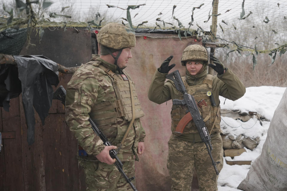 Dos soldados ucranianos (un hombre y una mujer) en el frente de combate. (AP Photo/Vadim Ghirda)