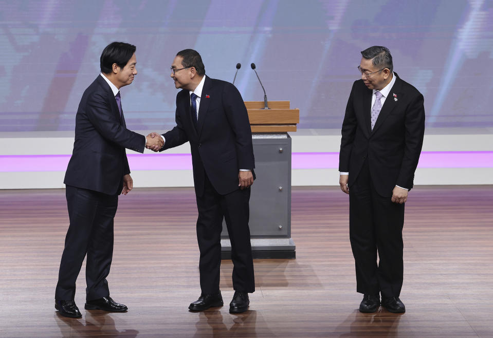 Taiwan President and Democratic Progressive Party presidential candidate William Lai, from left, shakes hands with Taiwan's Nationalist Party presidential candidate Hou Yu-ih while Taiwan's Taiwan People's Party (TPP) presidential candidate Ko Wen-je stands by before the presidential debates at Taiwan Public Television Service in Taipei, Taiwan, Saturday, Dec. 30, 2023. Taiwan will hold its presidential election on Jan. 13, 2024. (AP Photo/Pei Chen, Pool)