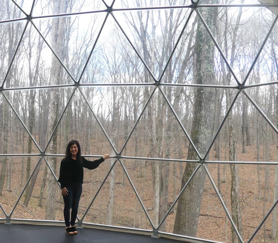 Owner Marci Hedderson-Carroll stands near the clear wall that overlooks the beautiful nature of Ross County.