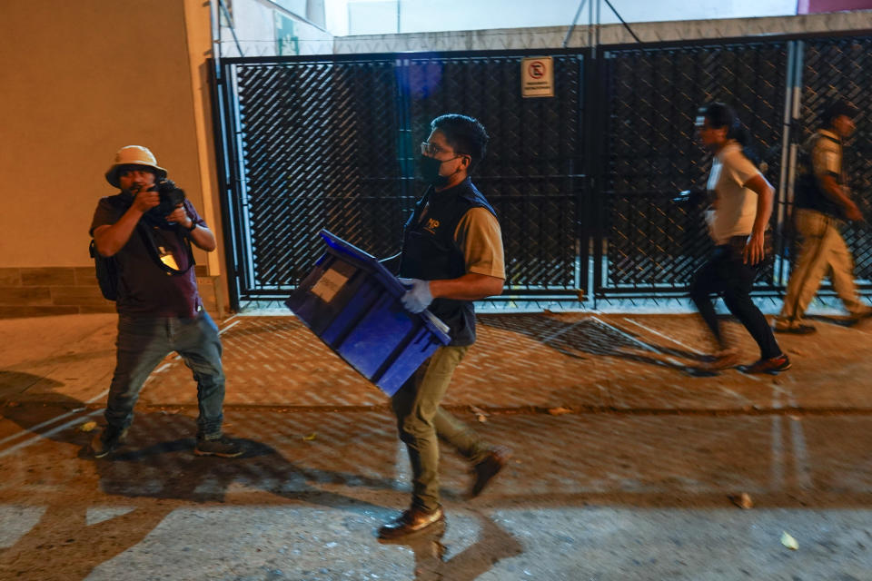 An agent from the Attorney General's office carries evidence collected at Save the Children's headquarters during a raid, in Guatemala City, Thursday, April 25, 2024. The NGO is being investigated for an alleged complaint about the violation of migrant children's rights, according to statements made by prosecutor Rafel Curruchiche. (AP Photo/Moises Castillo)