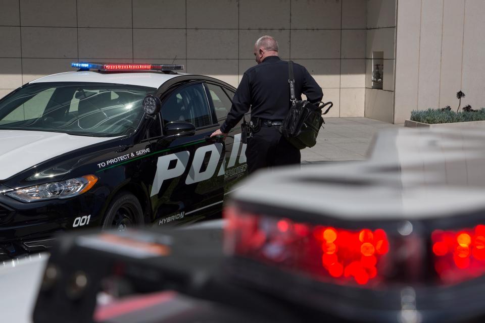 An LAPD officer looks at a car at the unveiling of two new Ford Fusion hybrid pursuit-rated Police Responder cars at Los Angeles Police Department headquarters on 10 April 2017 in Los Angeles, California (Getty Images)