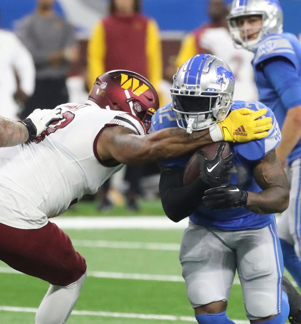 Detroit Lions running back D'Andre Swift is tackled by Washington Commanders defensive end Montez Sweat during the first half at Ford Field, Sept. 18, 2022.