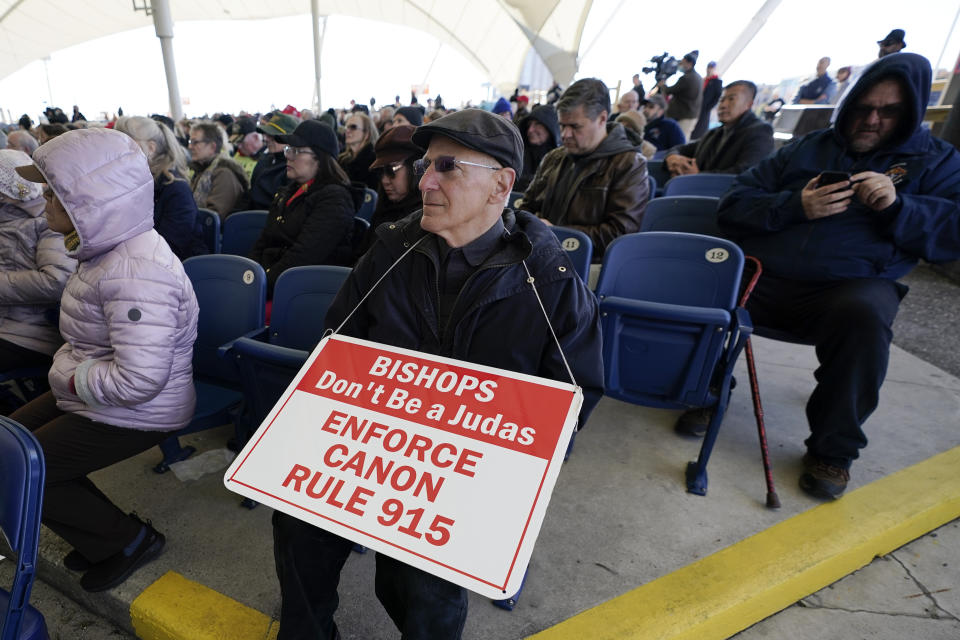 A man holds a sign during a rally outside of the Baltimore hotel where the United States Conference of Catholic Bishops are holding its Fall General Assembly meeting, Tuesday, Nov. 16, 2021, in Baltimore.(AP Photo/Julio Cortez)