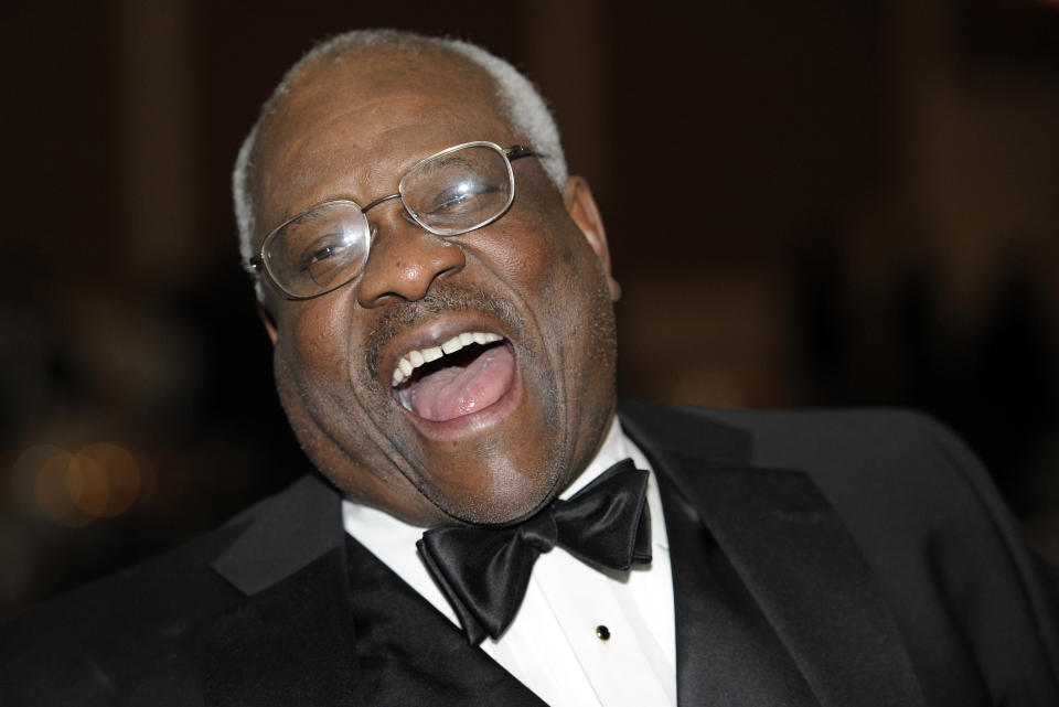 FILE - In this Nov. 10, 2011, file photo Supreme Court Justice Clarence Thomas laughs while talking with other guests at The Federalist Society's 2011 Annual Dinner in Washington. Thomas is now the longest-serving member of a court that has recently gotten more conservative, putting him in a unique and potentially powerful position, and he’s said he isn’t going away anytime soon. With President Donald Trump’s nominees Neil Gorsuch and Brett Kavanaugh now on the court, conservatives are firmly in control as the justices take on divisive issues such as abortion, gun control and LGBT rights.(AP Photo/Cliff Owen, File)