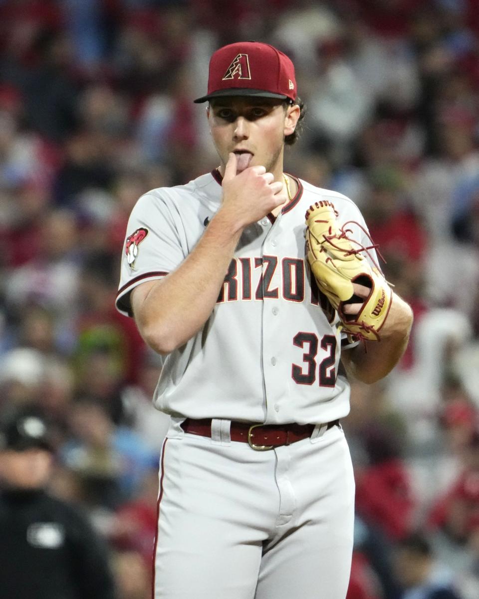 Arizona Diamondbacks starting pitcher Brandon Pfaadt (32) licks his thumb against the Philadelphia Phillies in the first inning during Game 7 of the NLCS at Citizens Bank Park in Philadelphia on Oct. 24, 2023.