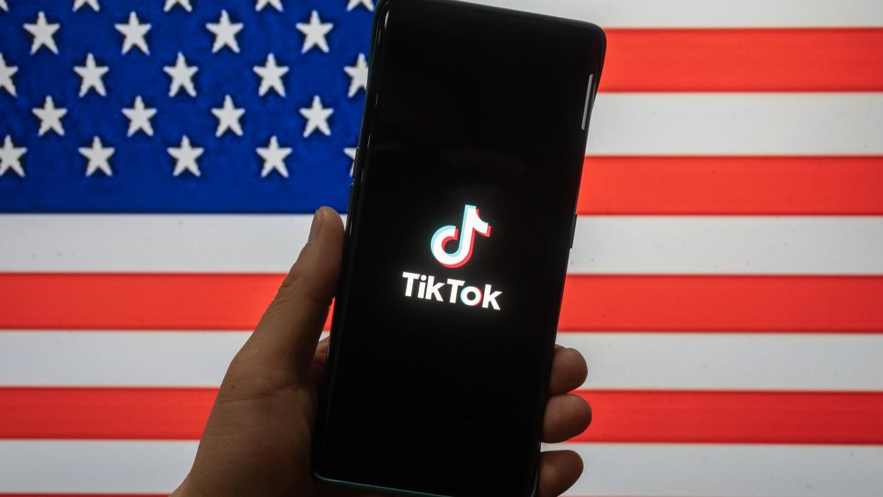  TikTok on a phone in front of the USA flag. 