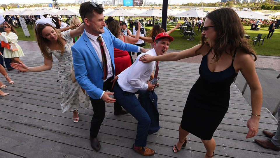 Racegoers, pictured here dancing at the end of Melbourne Cup Day. 
