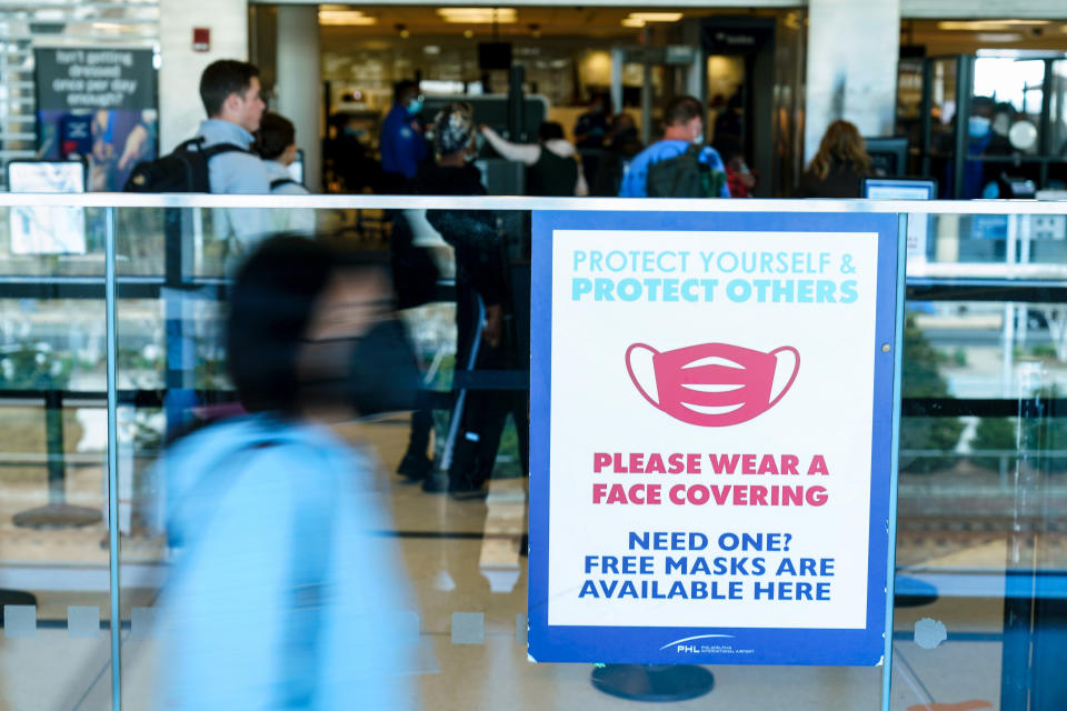 A sings is posted urging travelers to wear a protective masks as a precaution against the spread of the coronavirus at the Philadelphia International Airport in Philadelphia, Tuesday, April 19, 2022.  A federal judge's decision to strike down a national mask mandate was met with cheers on some airplanes but also concern about whether it's really time to end one of the most visible vestiges of the COVID-19 pandemic.  (AP Photo/Matt Rourke)