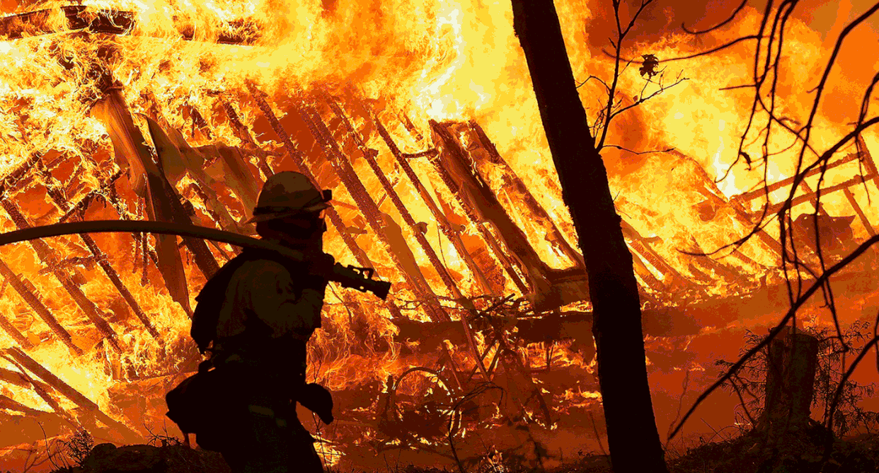 A Cal Fire firefighter monitors a burning home as the Camp Fire moves through the area on Nov. 9, 2018, in Magalia, Calif., and a view of a lot where a home burned down during the Camp Fire on Oct. 21, 2019, in Magalia, California. (Photos: Justin Sullivan/Getty Images)