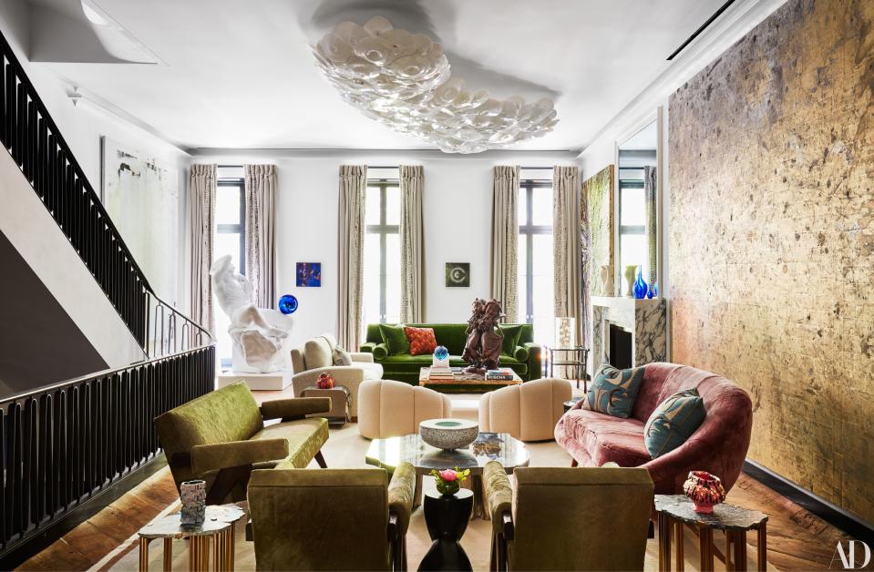 The living room of Allison and Warren Kanders's New York City townhouse features contemporary artworks by (from left) Christopher Wool, Jeff Koons, Gabriel Orozoo, Paul McCarthy, and Rudolf Stingel alongside vintage furniture.