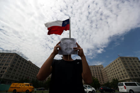 FILE PHOTO: A demonstrator holds up an image of Camilo Catrillanca, an indigenous Mapuche man who was shot in the head during a police operation in 'Ercilla' town south of Santiago, outside the government house in Santiago, Chile, November 22, 2018. REUTERS/Ivan Alvarado/File Photo